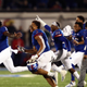 Members of the Kansas Jayhawks storm the field and celebrate as they defeat the Texas Tech Red Raiders during an Oct. 26, 2019, game. The NCAA is looking to change its rules to allow players like these to profit off their own names and images.